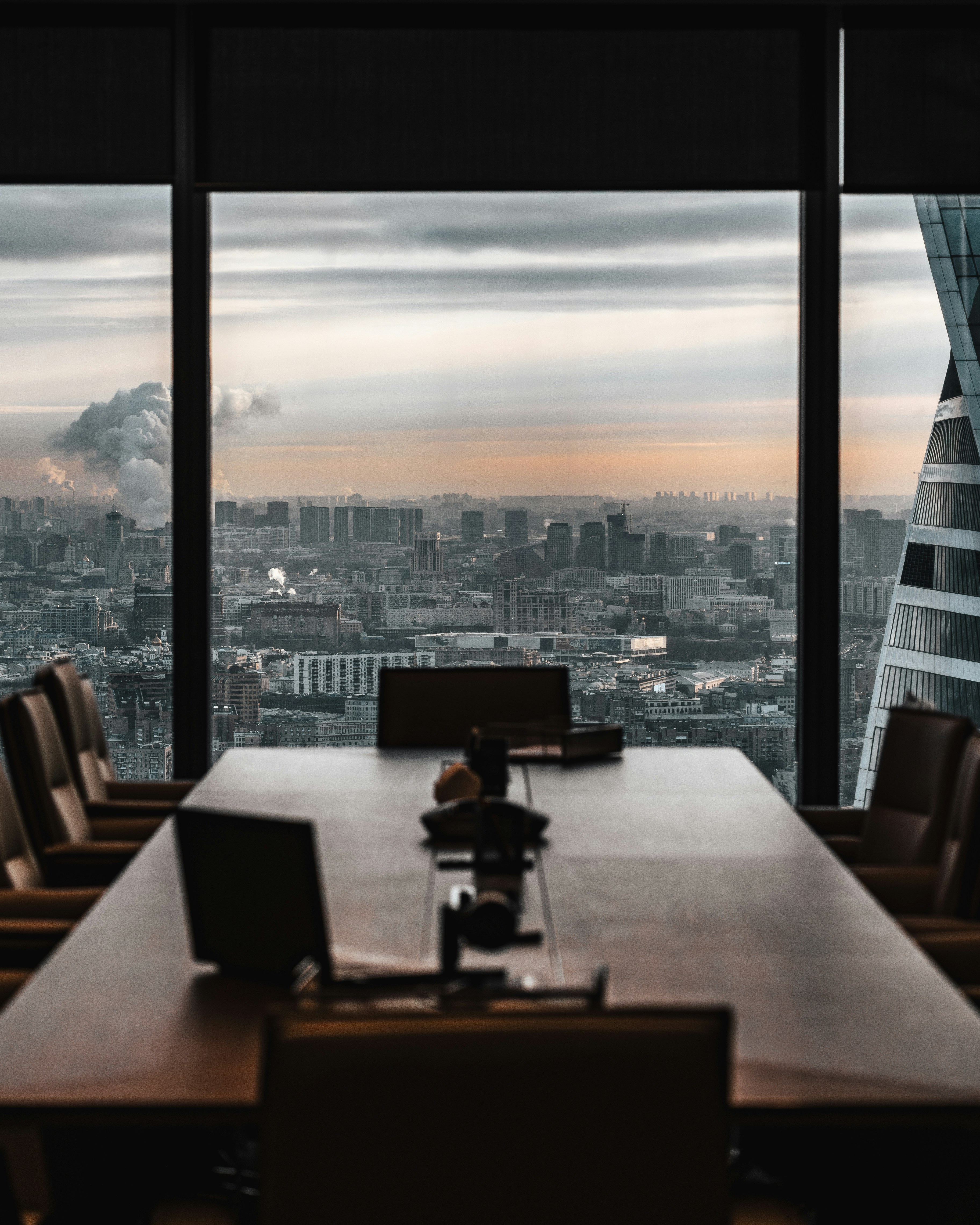 Conference table in an executive meeting room overlooking a city skyline